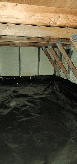 Attic space with wooden beams and black vapor barrier covering the floor.